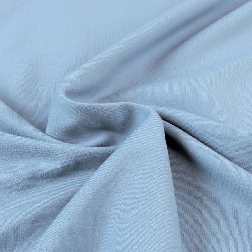Close-up view of light blue fabric showing smooth texture and draping.
